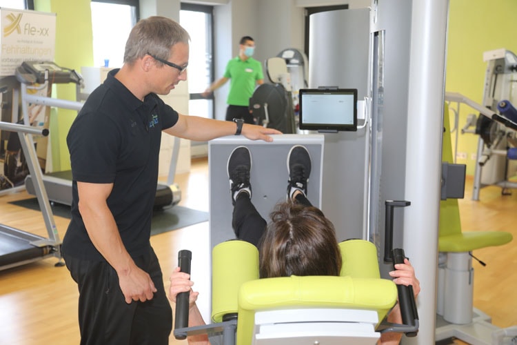 Die Physiotherapeut unterstützt den Patienten und zeigt ihm, welche Übungen während der Krankengymnastik am sinnvollsten sind.